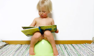 2-åring läser på pottan under potträningen
